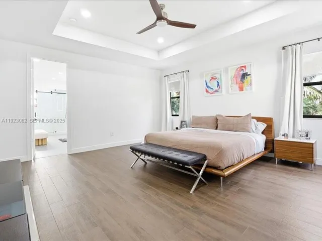 a bedroom with a bed wooden floor and window