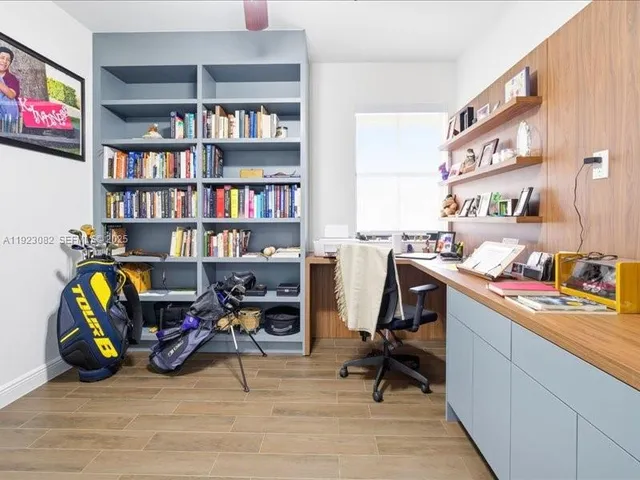 a view of a workspace with furniture and a bookshelf