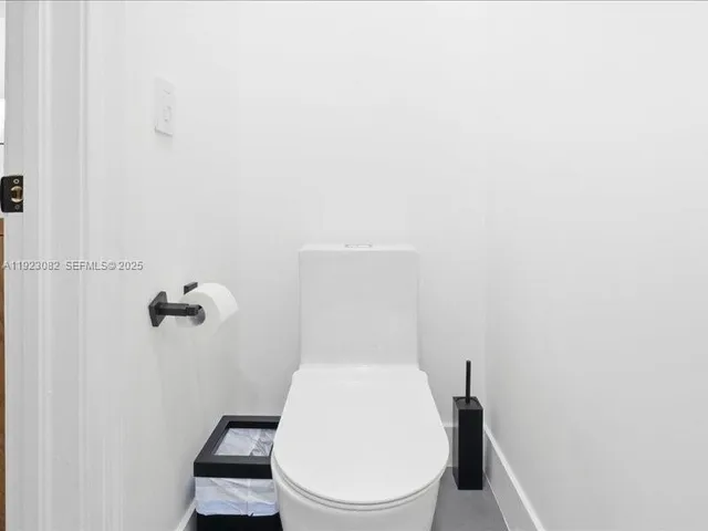 a white toilet sitting next to a shower