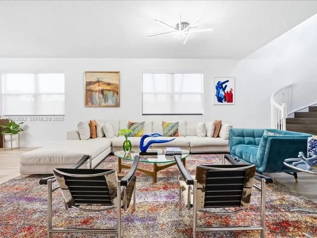 a living room with furniture a rug and a window