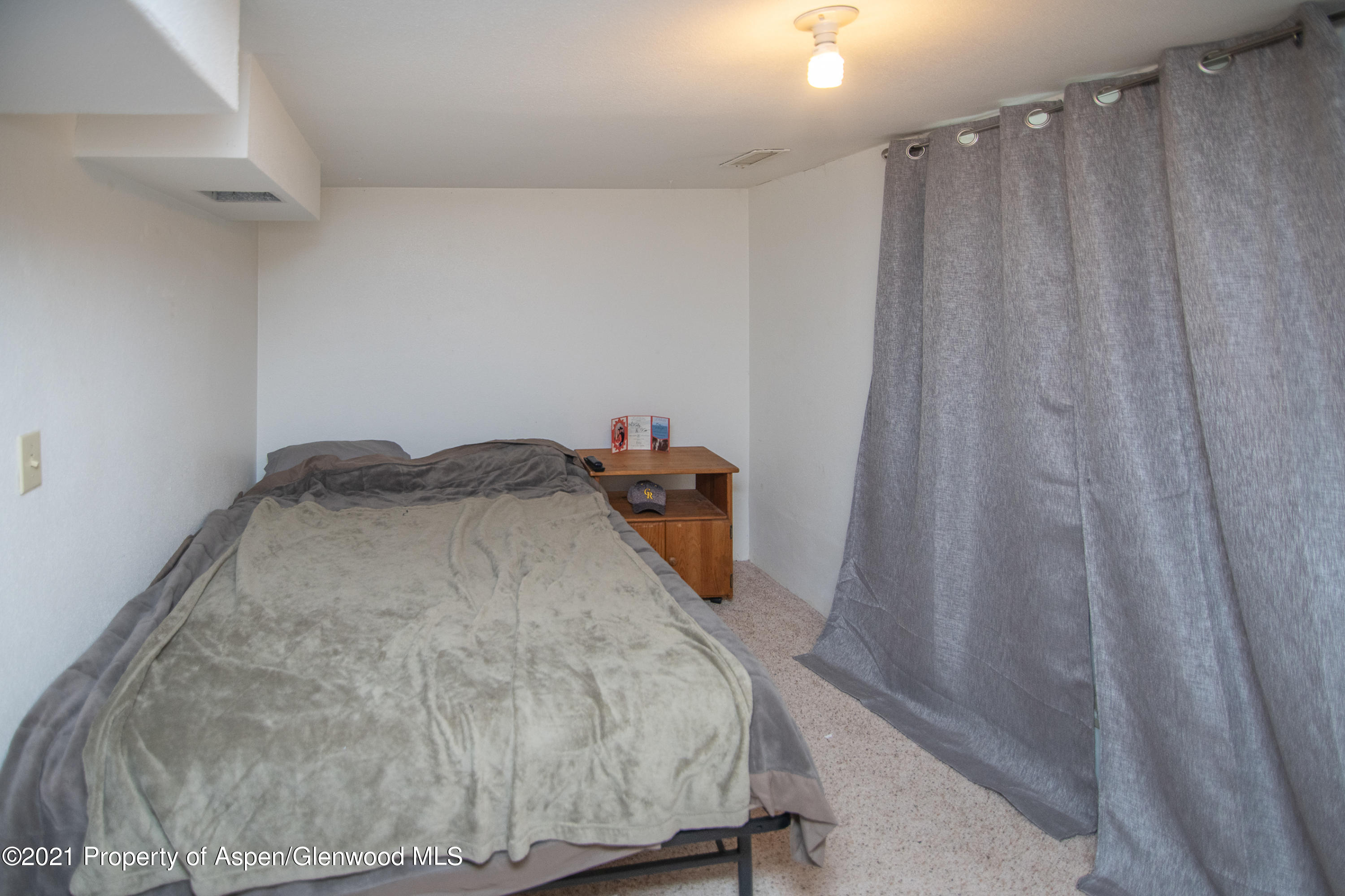 761 Rose Street Craig, CO 81625 - Photo 36 of 42 a bedroom with a bed and a curtain