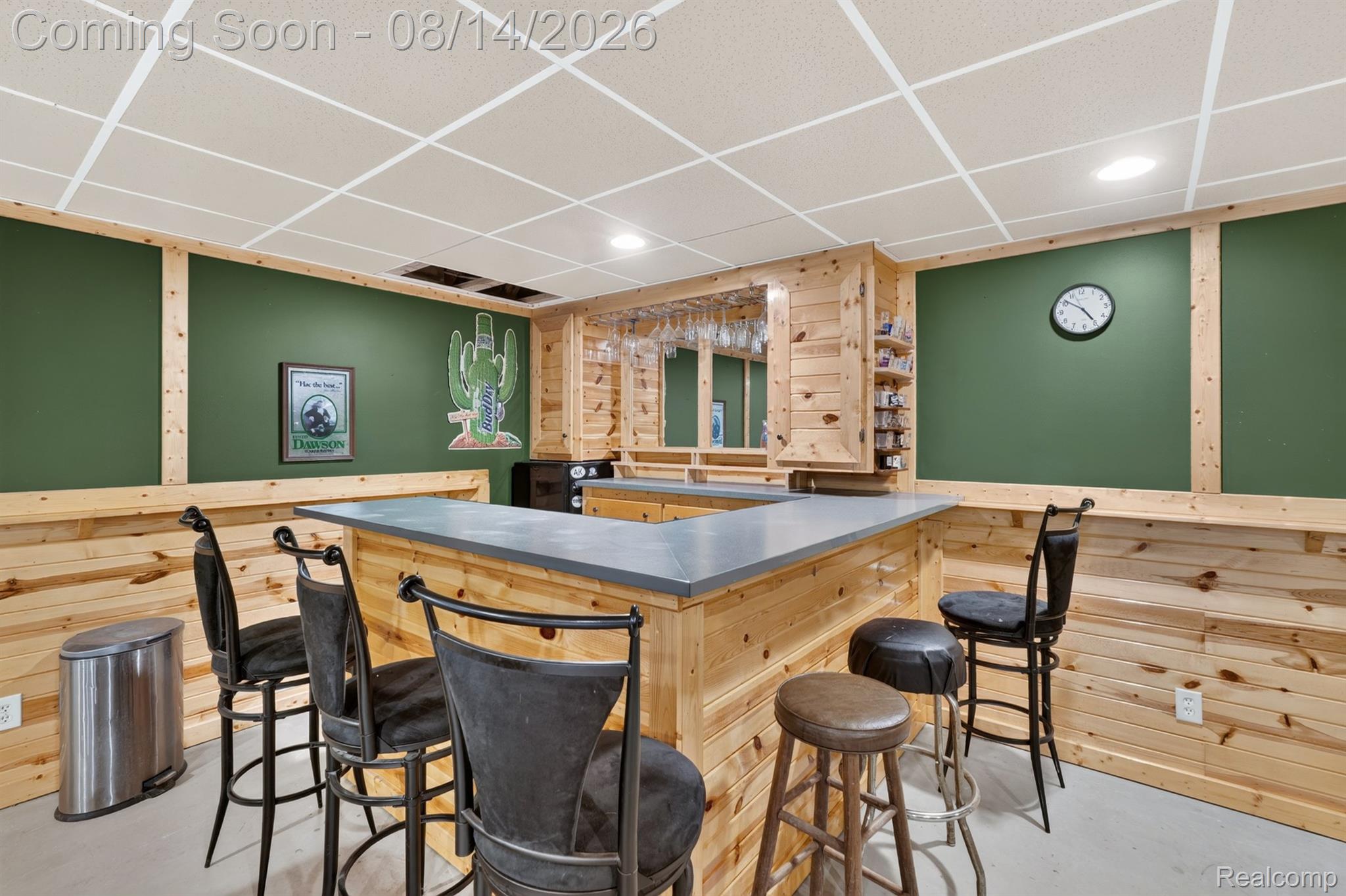 11342 South Morrish Road Gaines, MI 48436 - Photo 15 of 26 Built-in bar featuring a solid surface countertop, wood paneling, recessed lighting, and a suspended glass rack