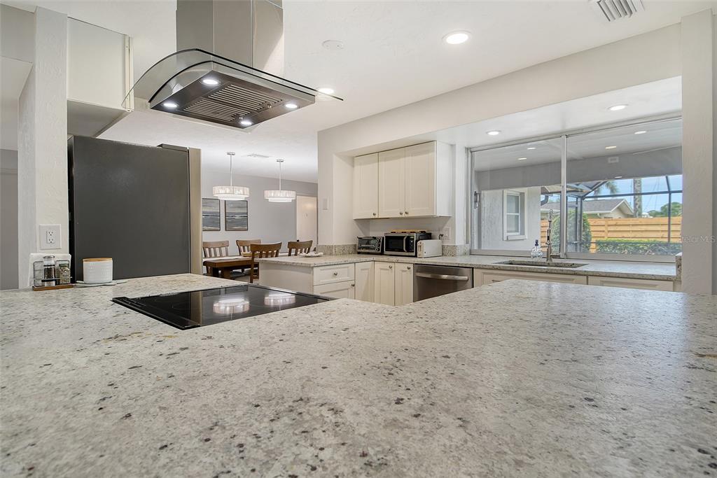 6722 Roxbury Drive Sarasota, FL 34231 - Photo 26 of 87 a kitchen with granite countertop a sink and white cabinets