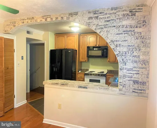 a kitchen with stainless steel appliances kitchen island granite countertop a refrigerator and a stove