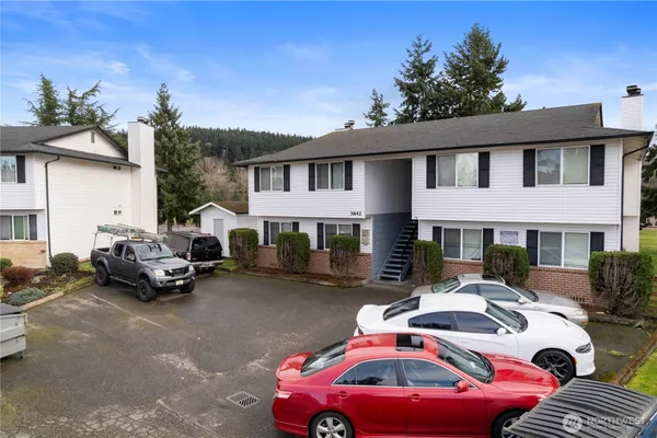 a front view of a house with cars parked