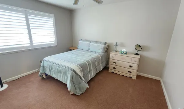 a bed room with a bed and two windows