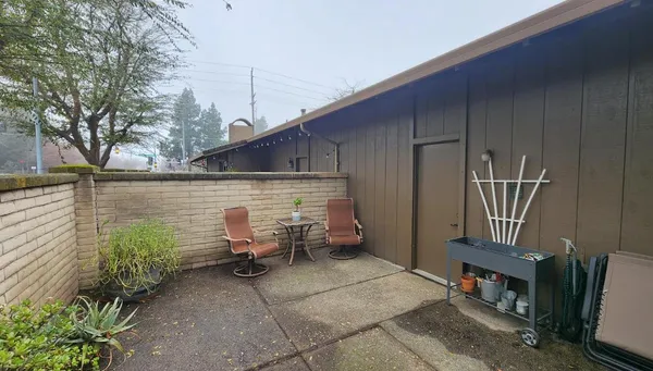 a view of patio with table and chairs and potted plants