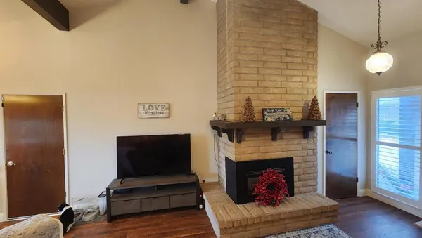 a living room with furniture a fireplace and a flat screen tv