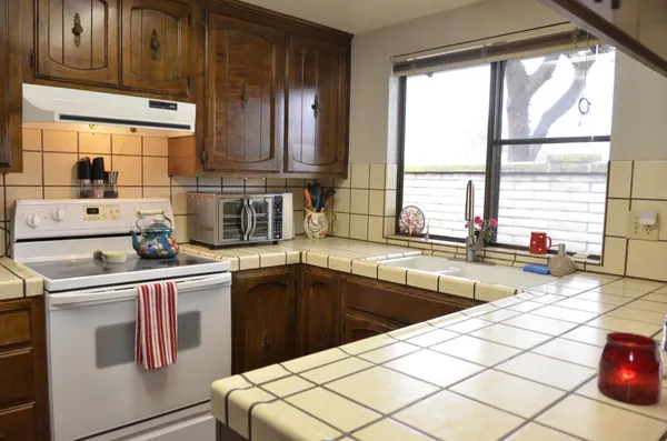a kitchen with stainless steel appliances kitchen island granite countertop a sink stove and cabinets