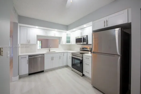 a kitchen with a refrigerator sink and stove top oven