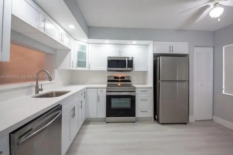a kitchen with stainless steel appliances a refrigerator sink and stove