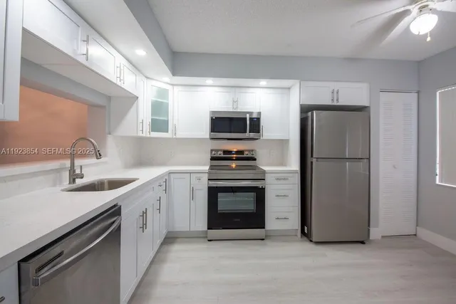 a kitchen with stainless steel appliances a refrigerator sink and stove