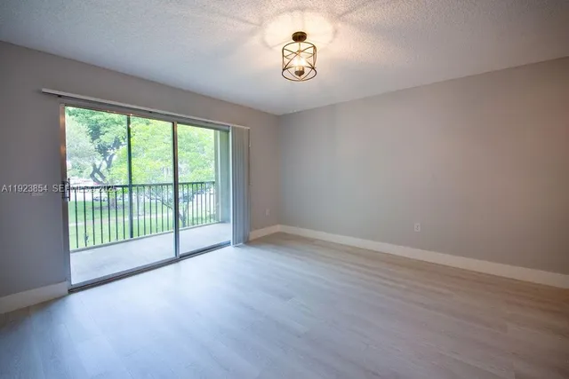 a view of a room with wooden floor and windows