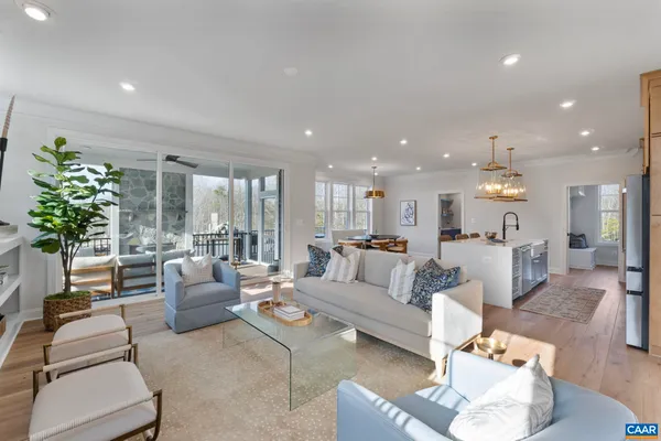 a large white kitchen with lots of counter space dining table and stainless steel appliances