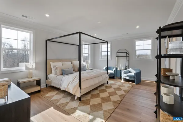 a bedroom with a large bed and a chandelier