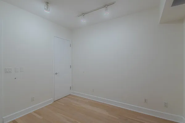 a bedroom with a bed mirror and paintings on the wall