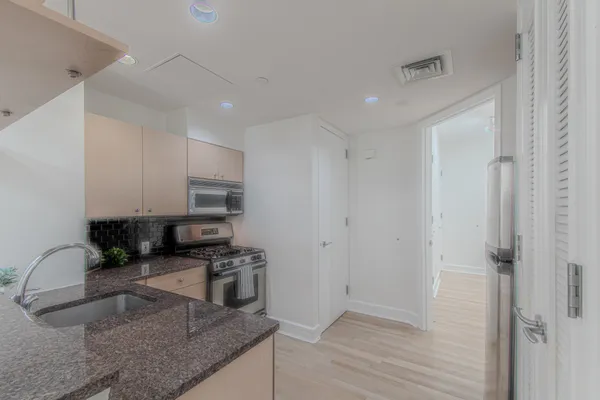 a kitchen with granite countertop a stove and a sink