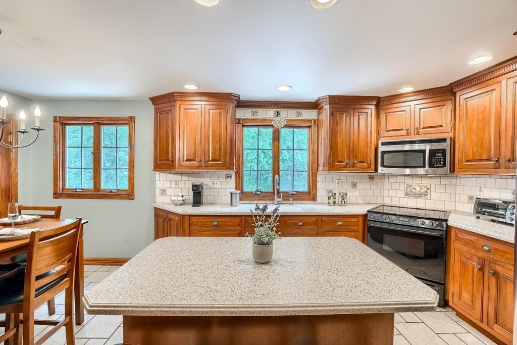 361 South Main Street Bellingham, MA 02019 - Photo 11 of 42 a kitchen with stainless steel appliances granite countertop a sink a stove top oven a dining table and chairs