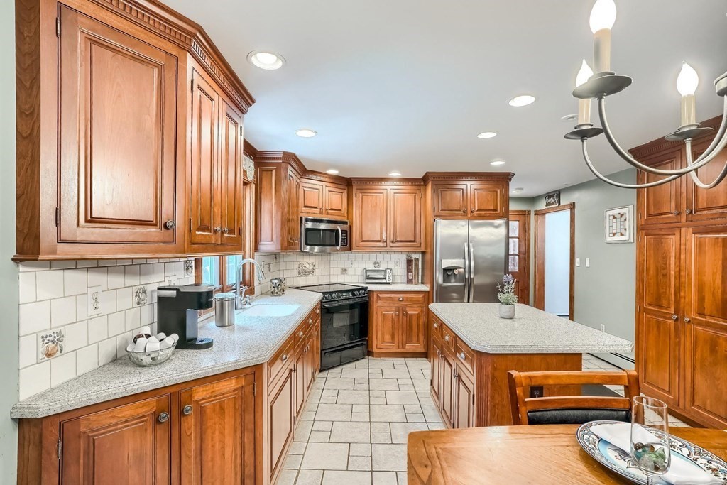 361 South Main Street Bellingham, MA 02019 - Photo 4 of 42 a kitchen with stainless steel appliances a sink a stove a refrigerator cabinets and living room view