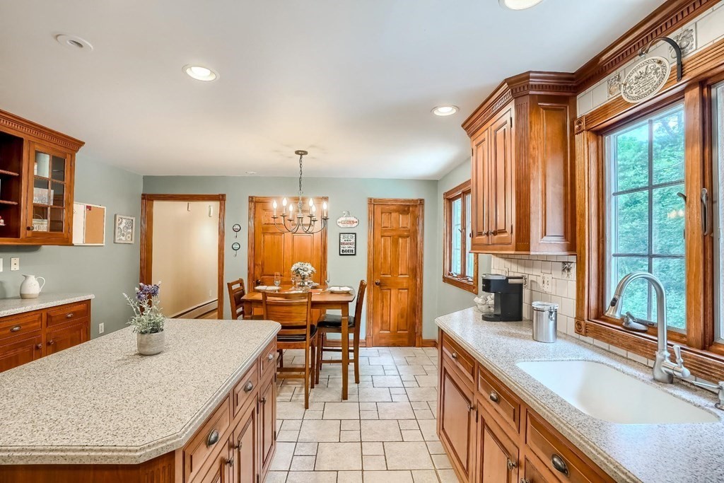 361 South Main Street Bellingham, MA 02019 - Photo 6 of 42 a dining hall with stainless steel appliances granite countertop a sink a stove and a dining table with the kitchen view