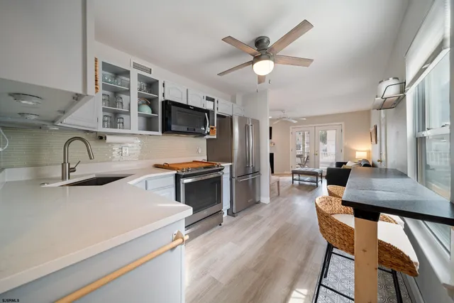 a kitchen with stainless steel appliances a stove a sink a microwave a dining table and chairs