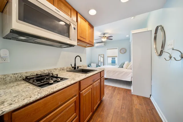 a kitchen with stainless steel appliances granite countertop a stove and a wooden floor