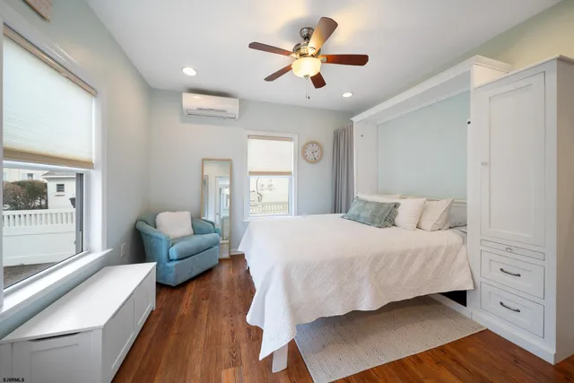a bedroom with a large bed chandelier and a window