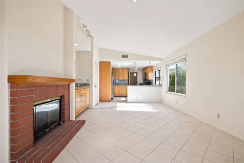 a view of an empty room with a fireplace and a window