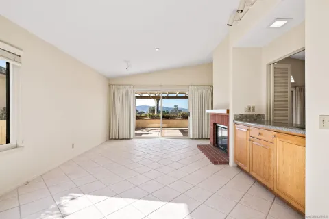 a large white kitchen with granite countertop a large window and a sink