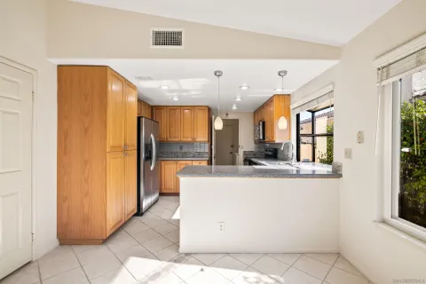 a view of kitchen with stainless steel appliances furniture refrigerator and large window