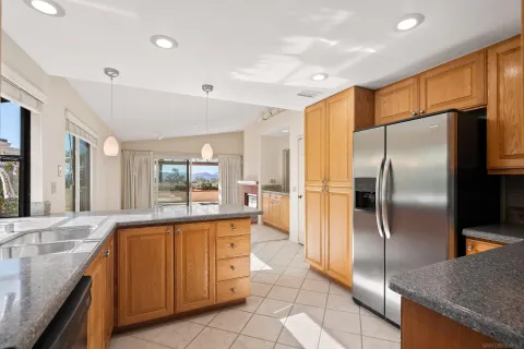 a kitchen with granite countertop a refrigerator and a sink