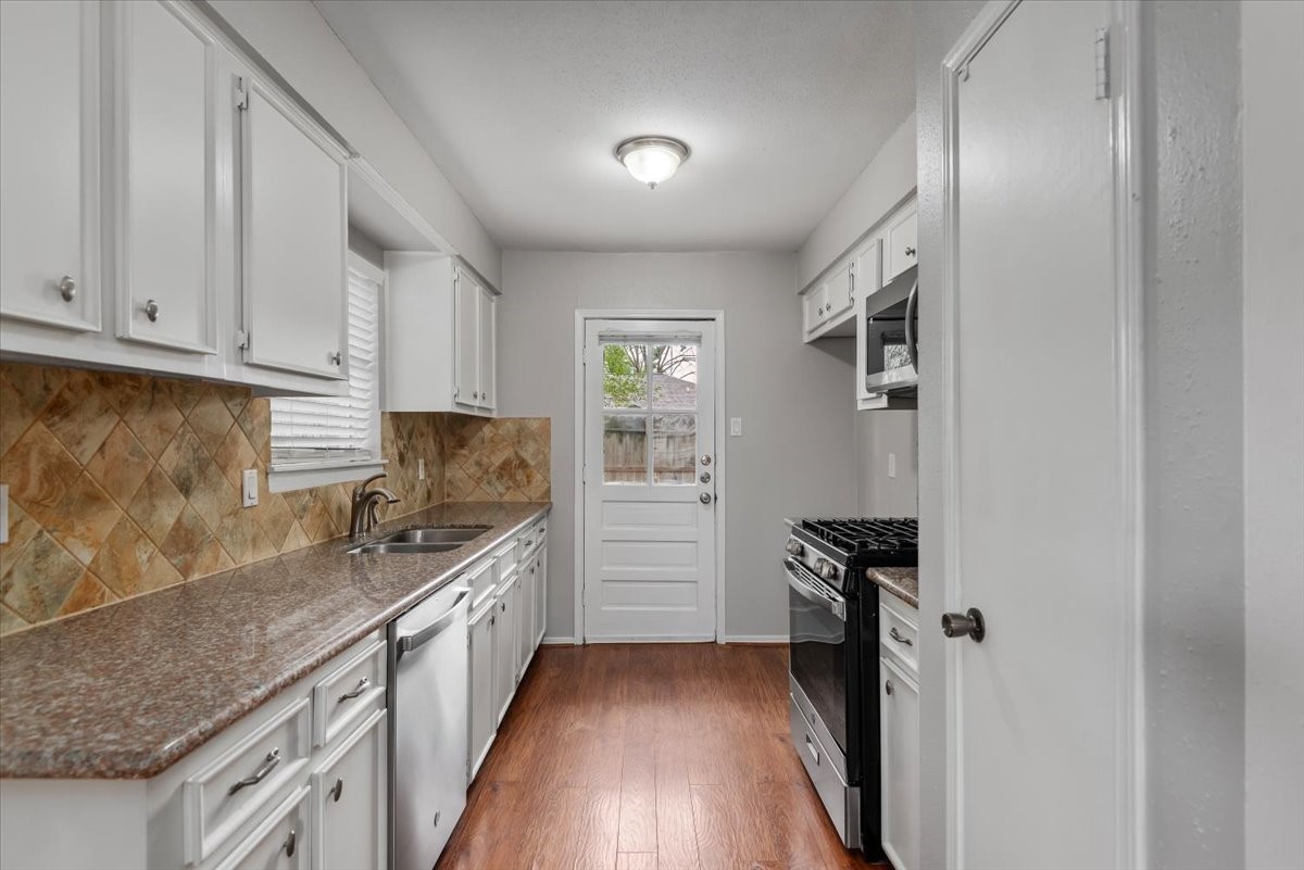 29414 Sedgefield Street Spring, TX 77386 - Photo 9 of 25 Galley style kitchen with black and stainless appliances. New dishwasher April 2026
