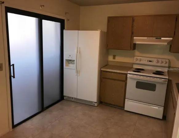 a kitchen with a stove and a refrigerator