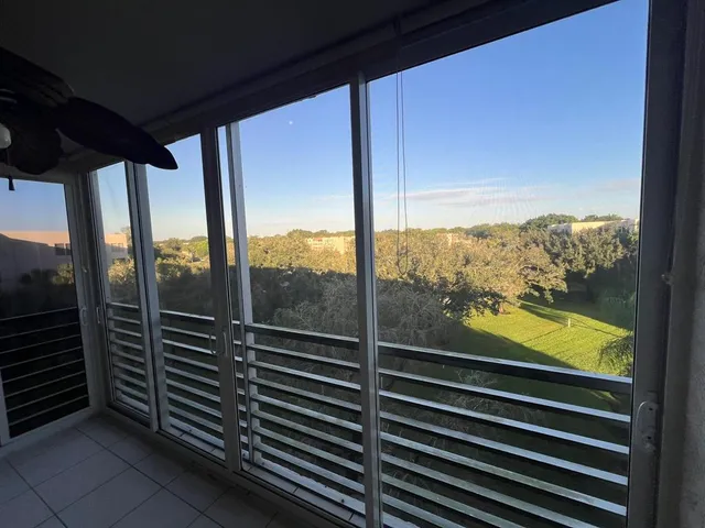 a view of a balcony with floor to ceiling windows with wooden floor