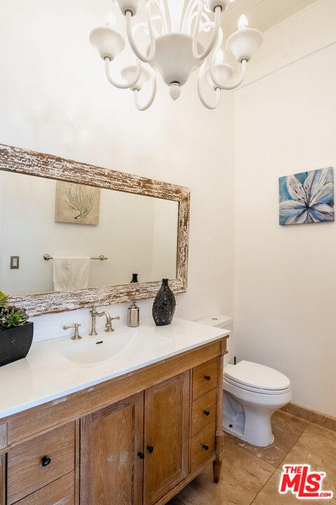 10090 Cielo Drive Beverly Hills, CA 90210 - Photo 6 of 19 a bathroom with a sink a toilet and mirror