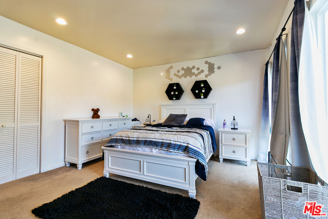 10090 Cielo Drive Beverly Hills, CA 90210 - Photo 10 of 19 a bedroom with a bed and a flat tv screen on wall