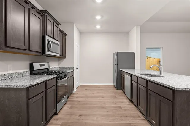 a kitchen with stainless steel appliances granite countertop a stove a sink and a refrigerator