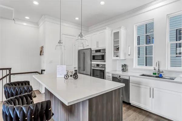 a kitchen with stainless steel appliances granite countertop a sink a stove and a refrigerator