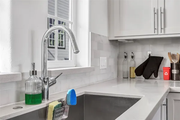 a kitchen with stainless steel appliances granite countertop a sink a stove and a wooden cabinets