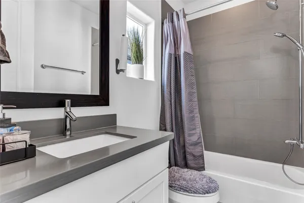 a bathroom with a tub sink and a mirror