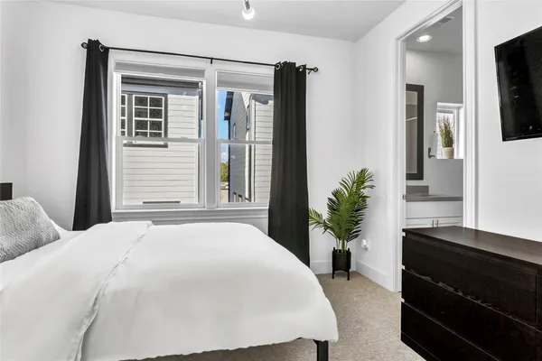 a bedroom with a large bed and a flat tv screen on dresser