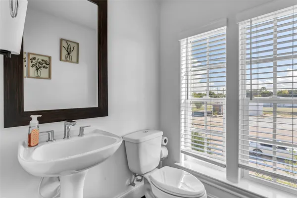 a bathroom with a toilet a sink and a mirror