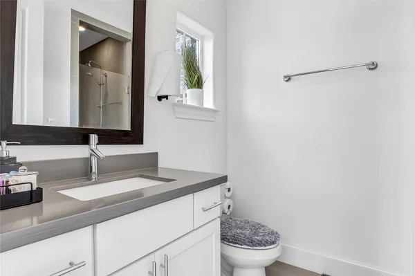 a bathroom with a granite countertop sink and a mirror