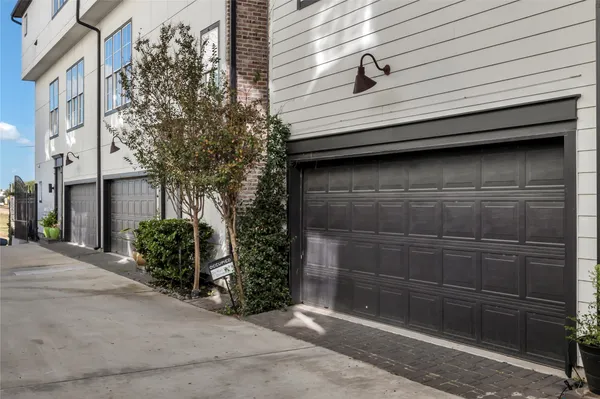 a small white building with a white roof and plants