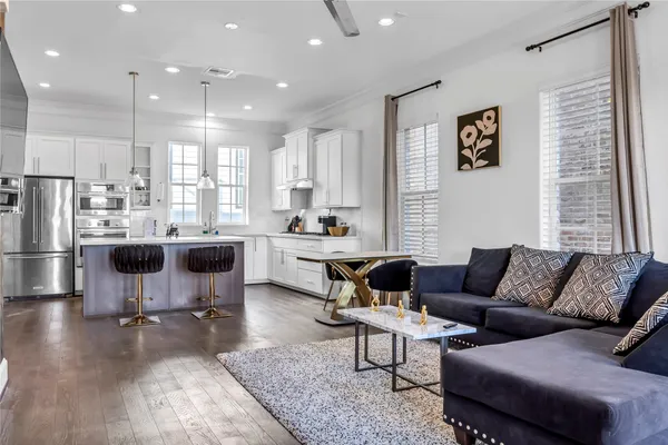 a living room with lots of furniture and kitchen view