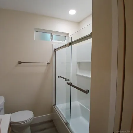 a bathroom with a sink a toilet and shower