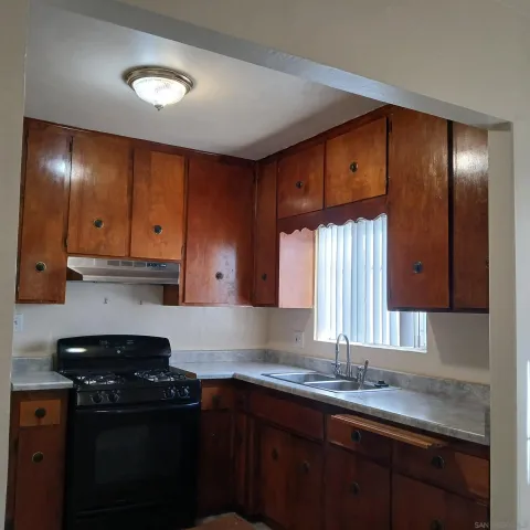 a kitchen with granite countertop a sink cabinets and stainless steel appliances