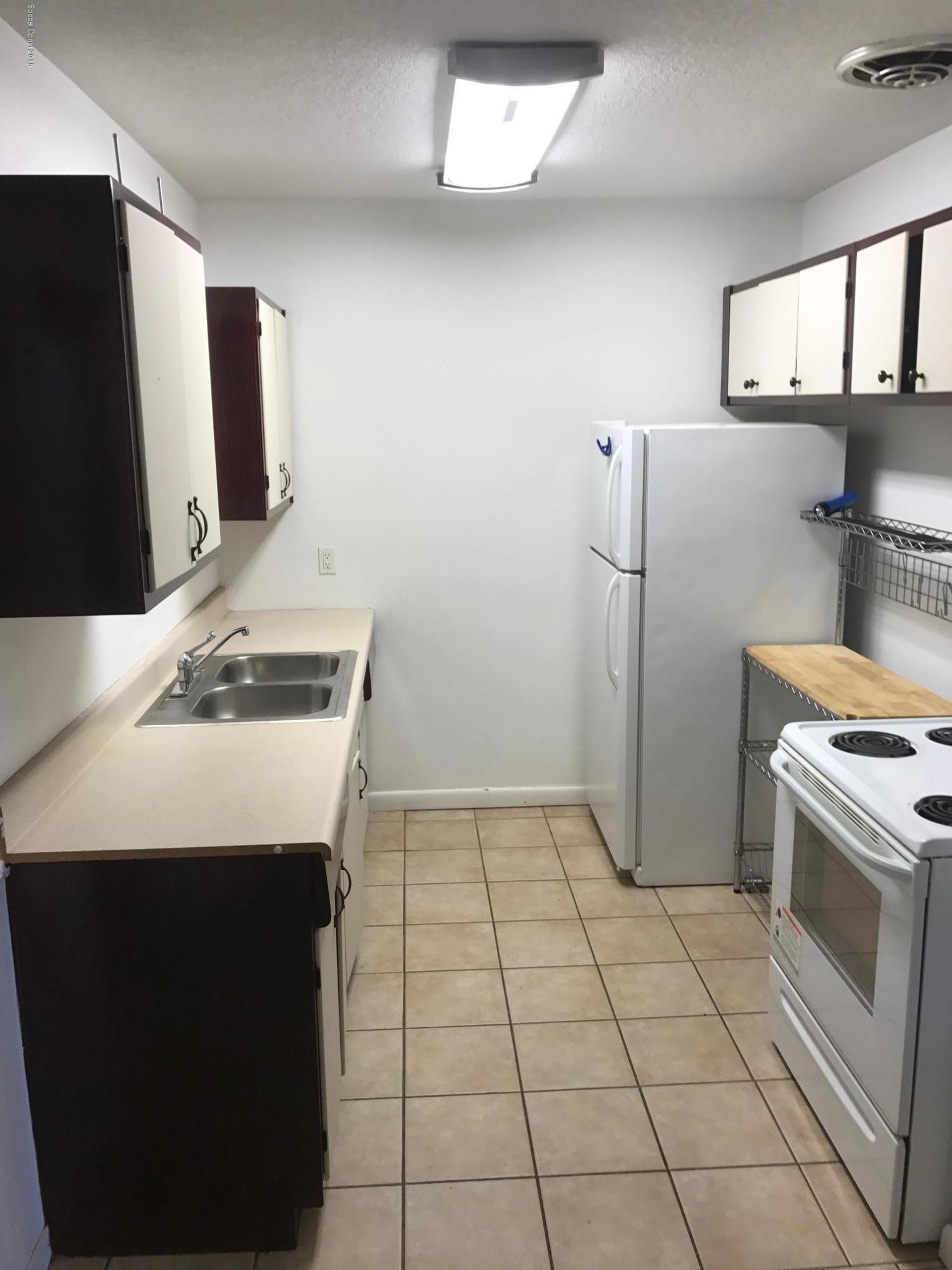 504 Cornell Avenue Melbourne, FL 32901 - Photo 2 of 10 a kitchen with a sink a stove and refrigerator
