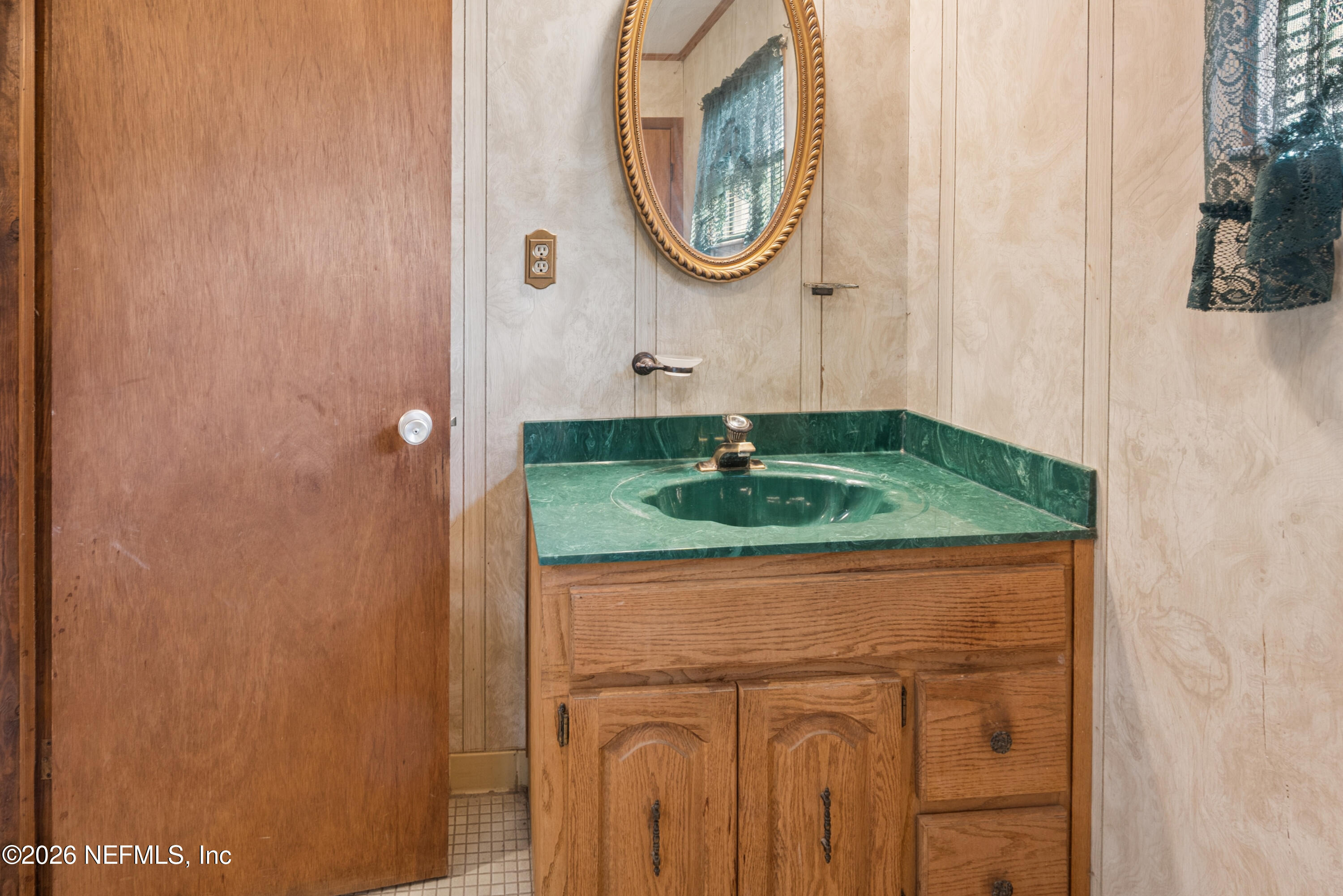 12781 Highway 100 Lake Butler, FL 32054 - Photo 75 of 100 a bathroom with a granite countertop sink and a mirror