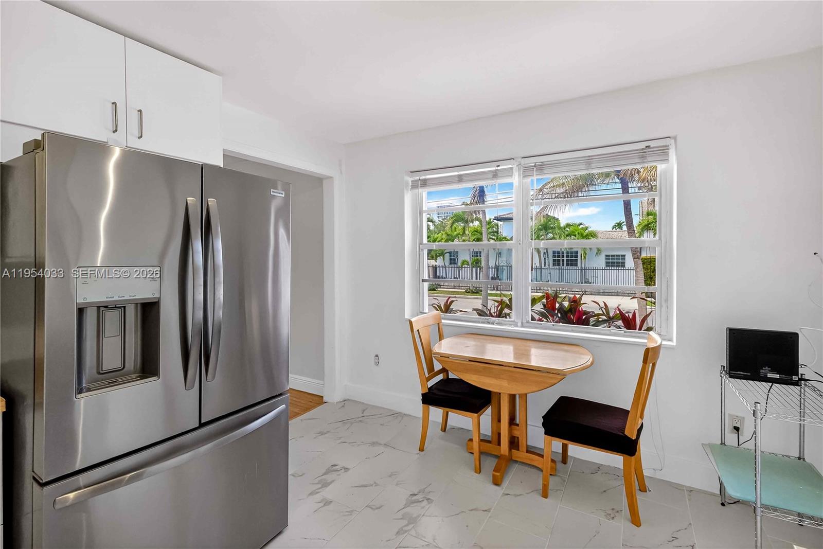 2399 Southwest 26th Lane Miami, FL 33133 - Photo 11 of 39 a kitchen with a refrigerator a table and chairs